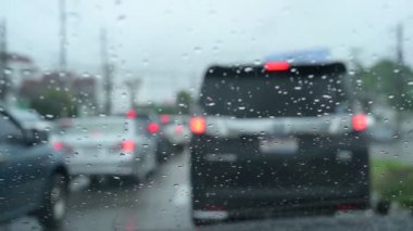 Yavaş çekim sahnesi, yağmurlu bir günde araba sürmek, cam silecekleri temiz yağmur damlaları.