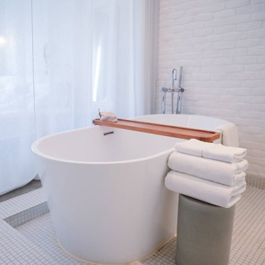 Havlu ve küvetli beyaz banyo.