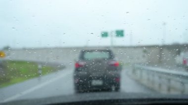 Yavaş çekim sahnesi, yağmurlu bir günde araba sürmek, cam silecekleri temiz yağmur damlaları.