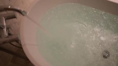 Ağır çekim sahnesi, küvette akan su.