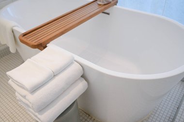 Banyoda küvete beyaz havlular konuldu.