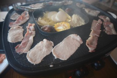 barbecue gril on black pot with meat and vegetable