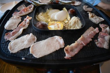 barbecue gril on black pot with meat and vegetable