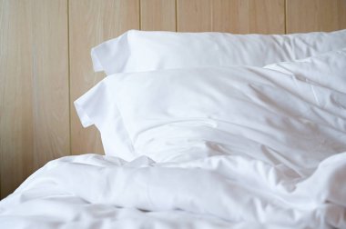 Beyaz yatak ve yastıklar odada.