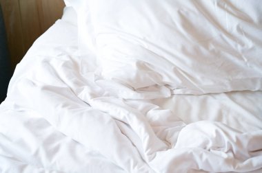 Beyaz yatak ve yastıklar odada.