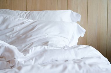 Beyaz yatak ve yastıklar odada.