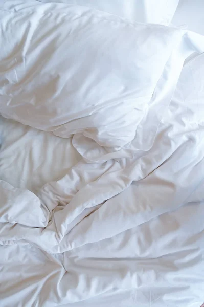white pillows on crumpled bed