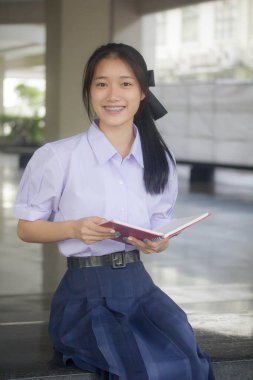 Taylandlı liseli üniformasının portresi. Genç güzel kız mutlu ve rahat.