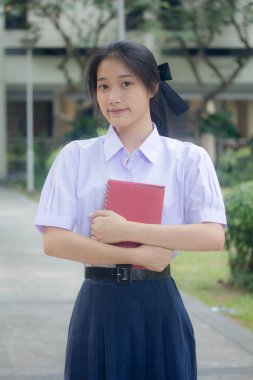 Taylandlı liseli üniformasının portresi. Genç güzel kız mutlu ve rahat.