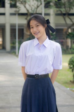 Taylandlı liseli üniformasının portresi. Genç güzel kız mutlu ve rahat.