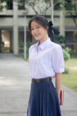 Taylandlı liseli üniformasının portresi. Genç güzel kız mutlu ve rahat.