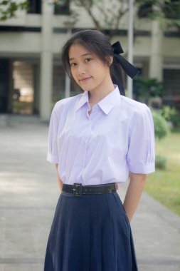 Taylandlı liseli üniformasının portresi. Genç güzel kız mutlu ve rahat.