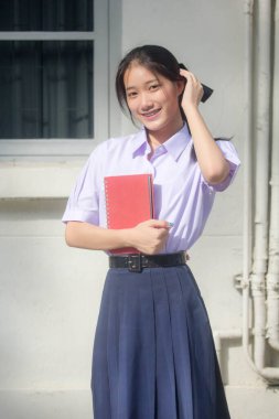 Taylandlı liseli üniformasının portresi. Genç güzel kız mutlu ve rahat.