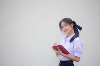 Asya Thai Lisesi üniformalı güzel kız. Bir kitap yaz.