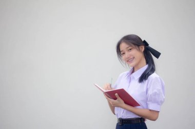 Asya Thai Lisesi üniformalı güzel kız. Bir kitap yaz.