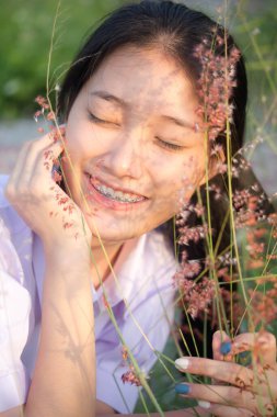 Taylandlı liseli üniformasının portresi. Genç güzel kız mutlu ve rahat.