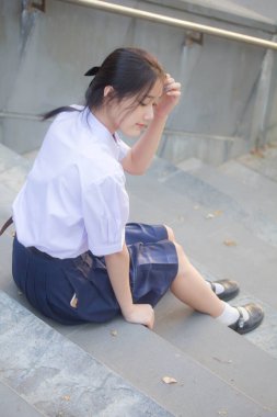 Taylandlı liseli üniformasının portresi. Genç güzel kız mutlu ve rahat.