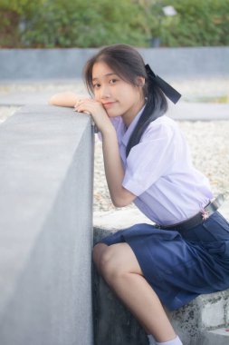 Taylandlı liseli üniformasının portresi. Genç güzel kız mutlu ve rahat.