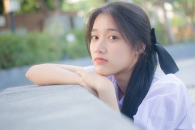 Taylandlı liseli üniformasının portresi. Genç güzel kız mutlu ve rahat.