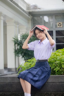 Taylandlı liseli üniformasının portresi. Genç güzel kız mutlu ve rahat.