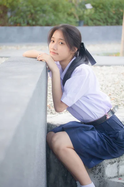 Taylandlı liseli üniformasının portresi. Genç güzel kız mutlu ve rahat.