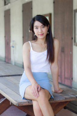 Taylandlı yetişkin portresi güzel kız beyaz gömlek açık mavi etek rahatlama zamanı