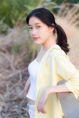 Asia Thai ergen sarı tişörtü güzel kız gülümse ve rahatla