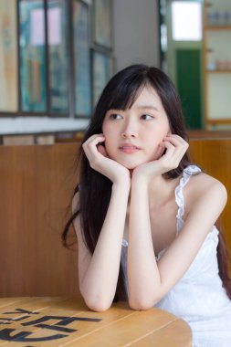 Asyalı thai kızı Beyaz elbiseli güzel kız gülümse ve rahatla