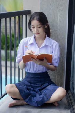 Asya Thai Lisesi üniformalı güzel kız. Bir kitap yaz.