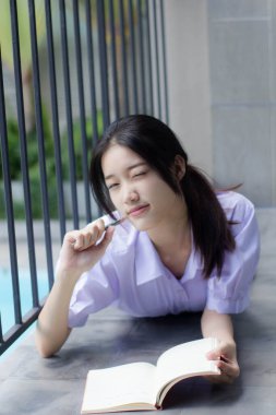Asya Thai Lisesi üniformalı güzel kız. Bir kitap yaz.