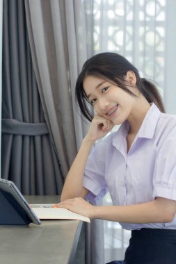 Asya Thai Lisesi üniformalı güzel kız. Bir kitap yaz.