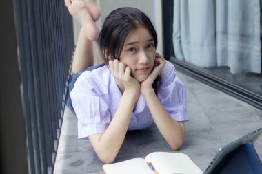 Asya Thai Lisesi üniformalı güzel kız. Bir kitap yaz.
