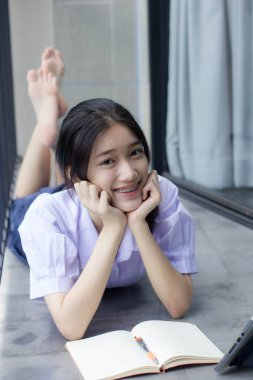 Asya Thai Lisesi üniformalı güzel kız. Bir kitap yaz.