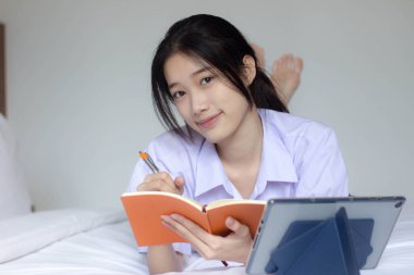 Asya Thai Lisesi üniformalı güzel kız. Bir kitap yaz.