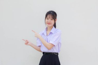 Asya Taylandlı lise öğrencisi üniforması. Güzel kız işaret ediyor.