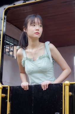 Asyalı kız yeşil elbise güzel kız gülümse ve rahatla