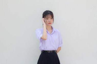 Asya Thai Lisesi öğrenci üniforması güzel bir kız akıllı telefondan arıyor.