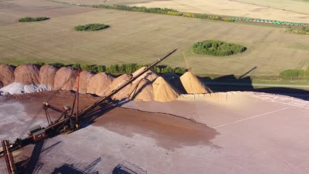 Letecký pohled na dopravník v solných jámách, těžba potaše a soli, dopravníkové vedení v pracovním procesu, solné lomy. Telestacker zpracovává rudu zblízka pro hromady odpadu z potaše. — Stock video