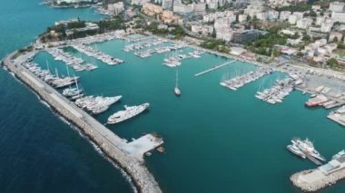 Türkiye 'nin Kusadasi kentinde tekne ve yatlarla bir marina üzerinde uçmak. Lüks tekneler rıhtıma demirlemiş, tatil köyünün yakınındaki dalgalarda yavaşça sallanıyorlar.. 