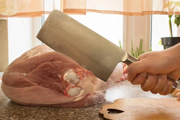 Balta kemikte büyük bir parça et keser. Yemek pişirme