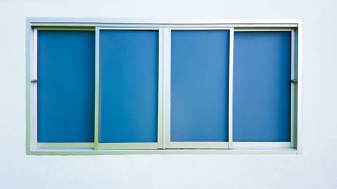 Açık yeşil duvarda alüminyum çerçeveli camlar.