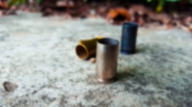 Bulanık boş tabanca mermileri beton zeminde atış poligonunda.