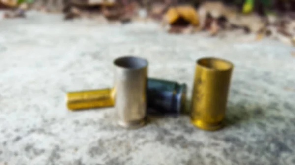 Bulanık boş tabanca mermileri beton zeminde atış poligonunda.