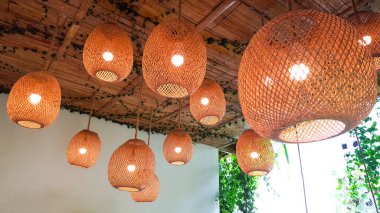 Kahverengi örülmüş bambu lambaları asılıydı.