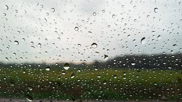 Transparente Wassertropfen Auf Glas Mit Verschwommenem Grauen Himmel Und Grünem — Stockfoto