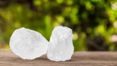 Kristal berrak alum küpleri ya da kahverengi tahta üzerinde potasyum alum. Kimyasal bileşik madde. Güzellik, kaplıca ve koltuk altı tedavi kavramı endüstriyel. 