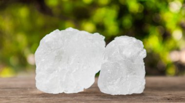 Kristal berrak alum küpleri ya da kahverengi tahta üzerinde potasyum alum. Kimyasal bileşik madde. Güzellik, kaplıca ve koltuk altı tedavi kavramı endüstriyel. 