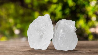 Kristal berrak alum küpleri ya da kahverengi tahta üzerinde potasyum alum. Kimyasal bileşik madde. Güzellik, kaplıca ve koltuk altı tedavi kavramı endüstriyel. 