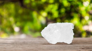 Kristal berrak alum küpleri ya da kahverengi tahta üzerinde potasyum alum. Kimyasal bileşik madde. Güzellik, kaplıca ve koltuk altı tedavi kavramı endüstriyel. 