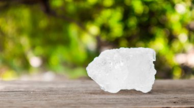 Kristal berrak alum küpleri ya da kahverengi tahta üzerinde potasyum alum. Kimyasal bileşik madde. Güzellik, kaplıca ve koltuk altı tedavi kavramı endüstriyel. 